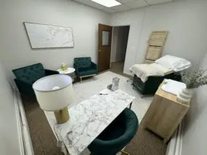 vitaledge health and wellness exam room with green chairs marble desk exam table soft neutral decor and calming modern accents