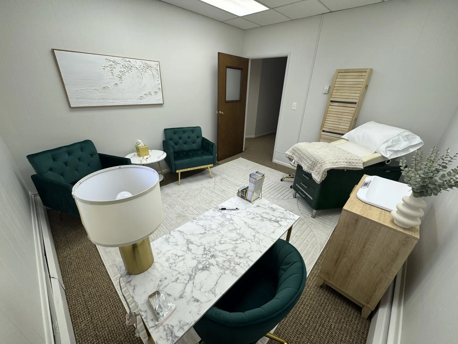 vitaledge health and wellness exam room with green chairs marble desk exam table soft neutral decor and calming modern accents